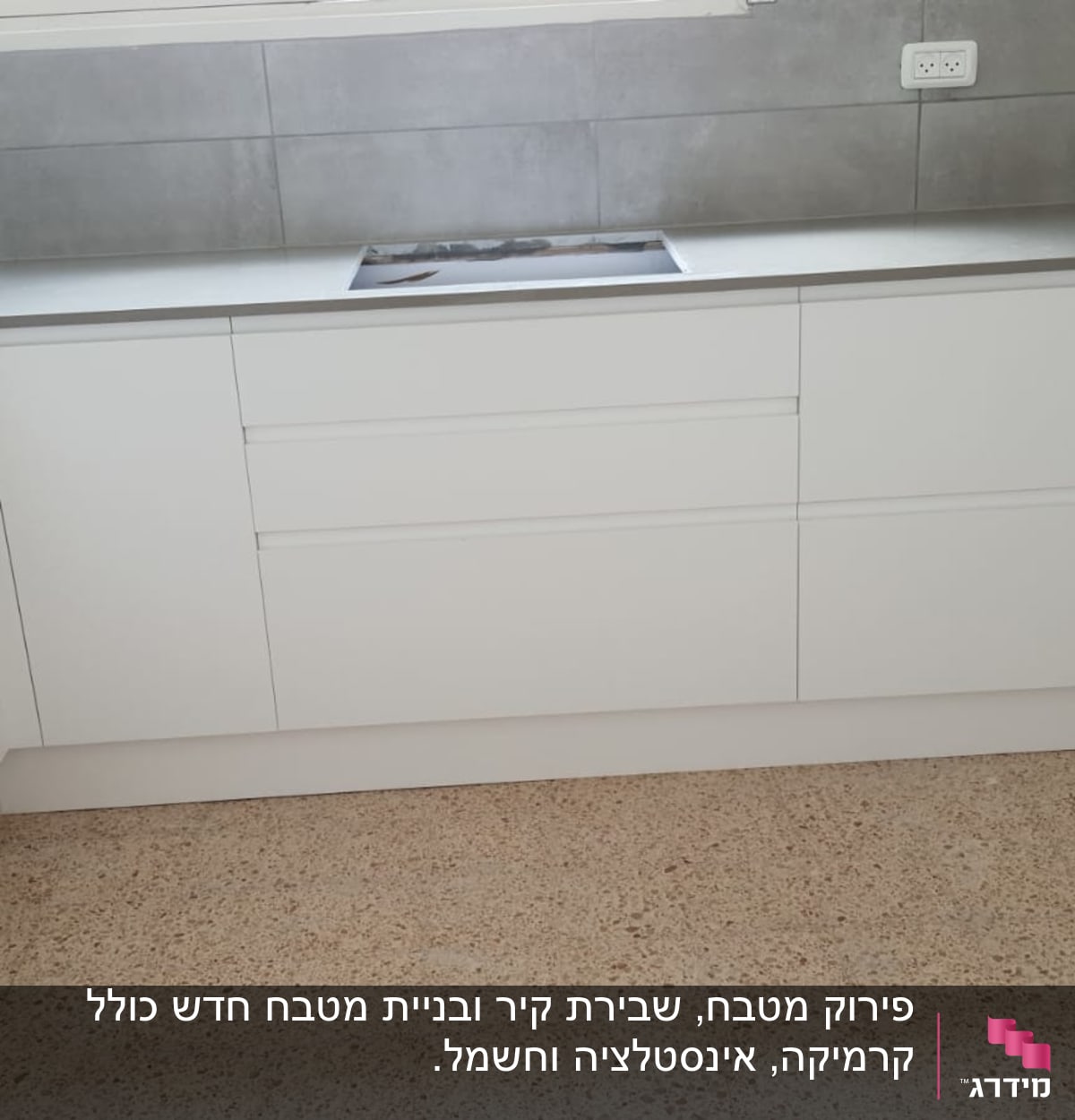 מטבח חדש עם ארונות לבנים ומשטח עבודה אפור